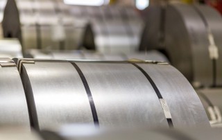 This image is a close up on a roll of advanced high-strength steel, laying amongst many others in one of National Material’s steel service facilities.