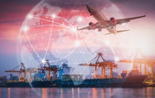 On a photograph of a dock with a large freight ship in front of four giant cranes, a large airplane and a watermark of the globe have been superimposed to represent world trade.