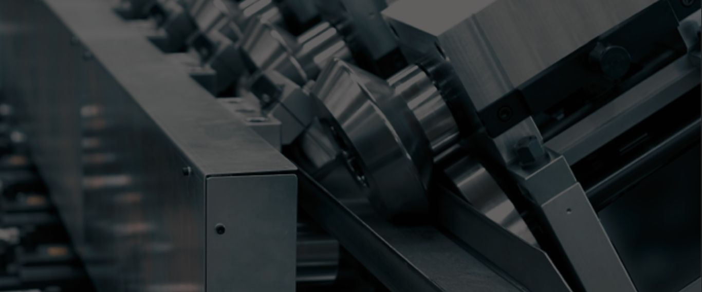 Detailed view of shiny metal rollers and components in an industrial machine used for manufacturing or processing.