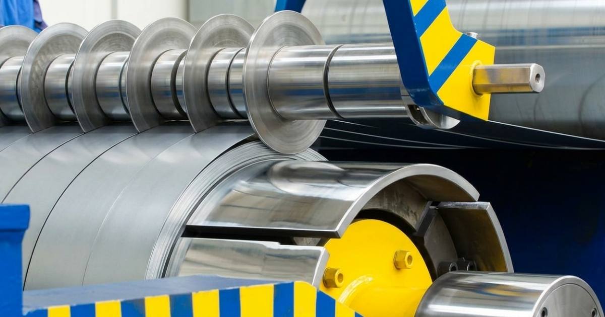 A close-up shot of a high-speed industrial slitting machine, representing vital part of the precision metal processing process.