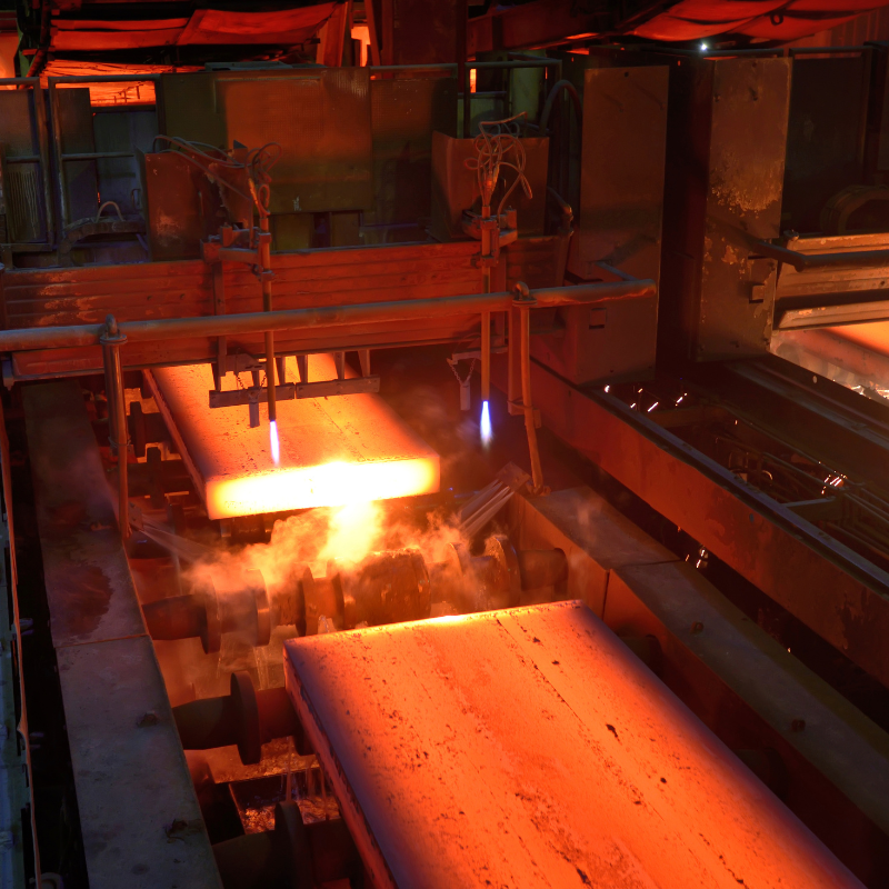 Hot steel being cut in a manufacturing facility.
